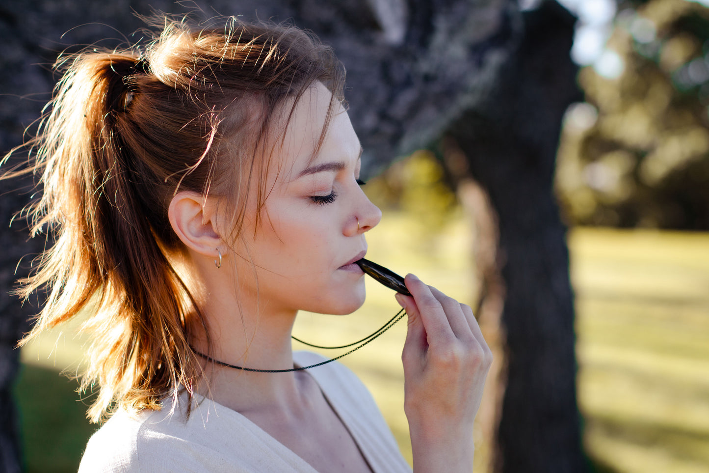 woman closing eyes, woman breathing, anxiety necklace, breathing necklace, Hā tool, Ha tool, nz anxiety whistle, anxiety whistles